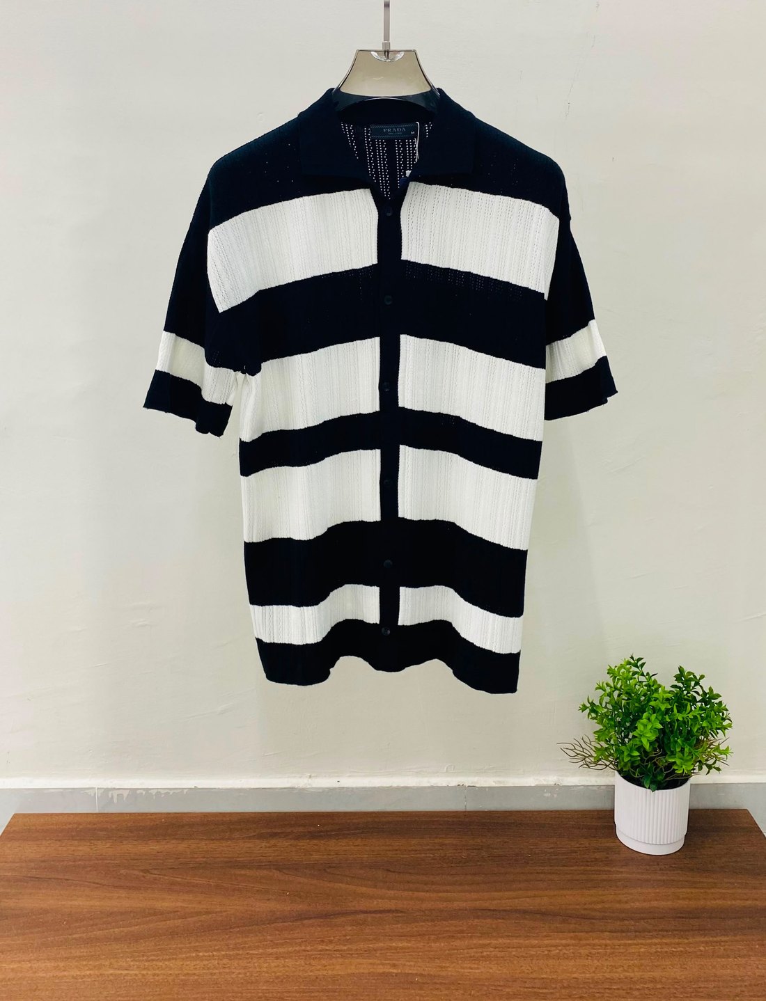 Black and white striped knit shirt on a hanger