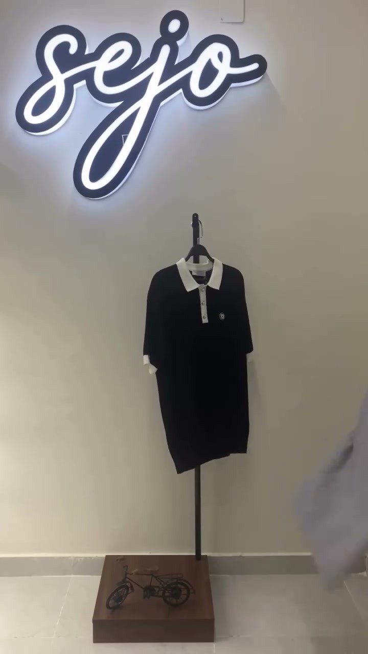 The Sejo neon sign above a shirt on display